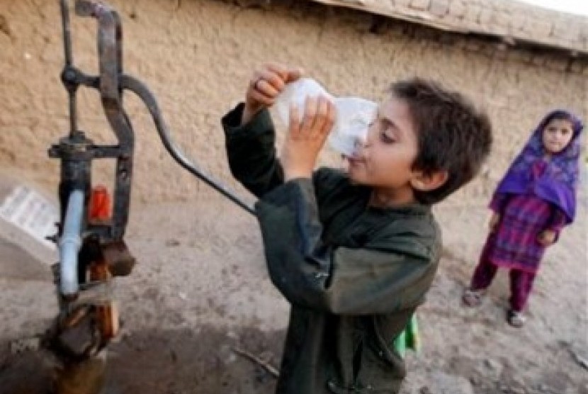 Seorang bocah Pakistan meminum air dari pompa umum di pinggir kota Islamabad. Pakistan menghadapi krisis parah akibat kombinasi pembengkakan populasi dan kegagalan pertanian yang membuat pasokan bersih berkurang.