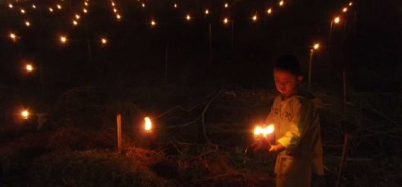 Seorang bocah tengah memasang lampu dalam perayaan Tumbilotihe di Gorontalo.