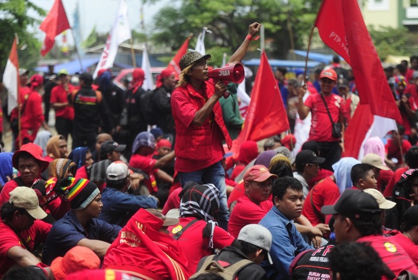 Seorang buruh berorasi ketika mengikuti aksi mogok di Kawasan Industri Pulogadung, Jakarta, Selasa (24/11).