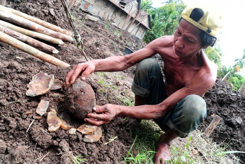 Seorang buruh lepas, Ilias (48) memegang sebuah mortir yang ditemukannya di Gang Cendana, Kec. Sungai Rengas, Kubu Raya, Kalbar, Kamis (26/7). Mortir peninggalan militer Belanda pada masa Perang Dunia ke-II itu ditemukan ketika menggali tanah di lahan koso