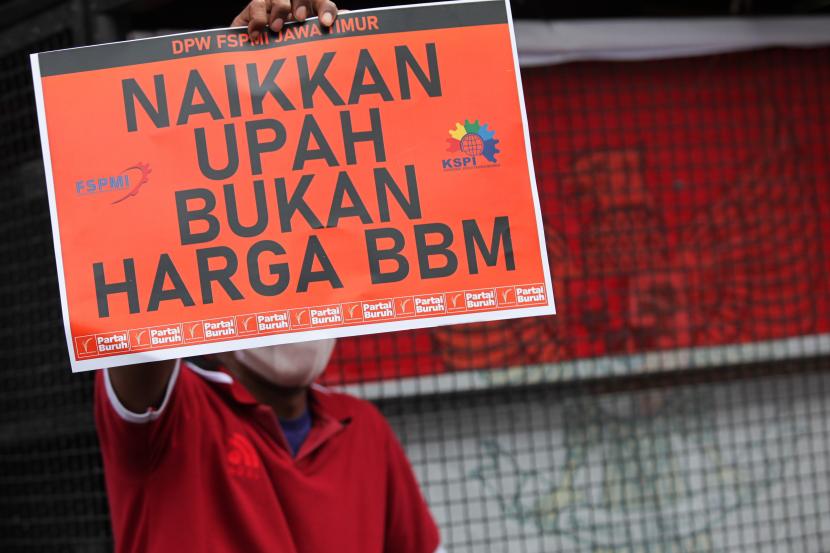 Seorang buruh membentangkan poster saat berunjuk rasa di Jalan Gubernur Suryo, Surabaya, Jawa Timur, Rabu (31/8/2022). Mereka menyerukan sejumlah tuntutan salah satunya menolak rencana kenaikan harga bahan bakar minyak (BBM).