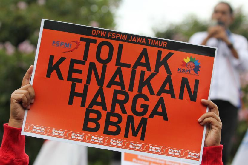 Seorang buruh membentangkan poster saat berunjuk rasa di Jalan Gubernur Suryo, Surabaya, Jawa Timur, Rabu (31/8/2022). Mereka menyerukan sejumlah tuntutan salah satunya menolak rencana kenaikan harga bahan bakar minyak (BBM).