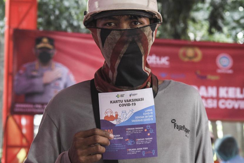 Seorang buruh pabrik menunjukkan kartu usai vaksinasi COVID-19 dosis ketiga di Cikarang, Kabupaten Bekasi (ilustrasi)