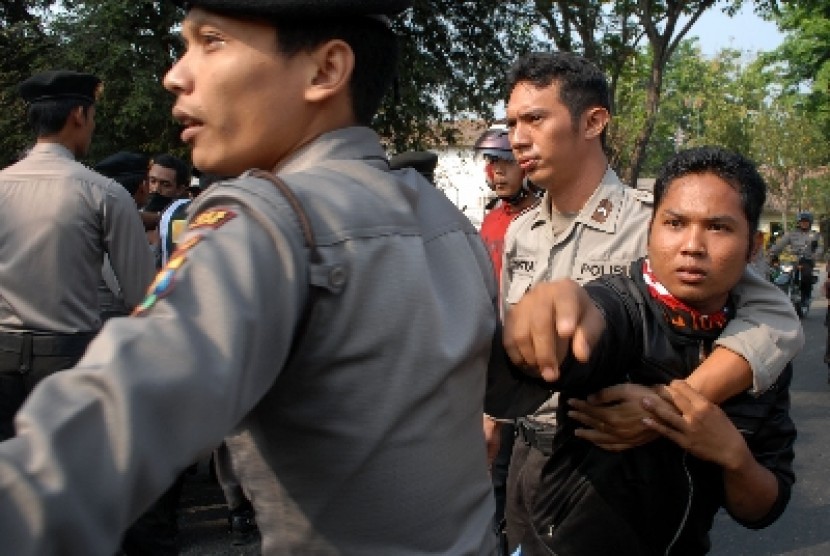 Seorang buruh PT Mentari International (kanan) diamankan petugas saat melakukan aksi sweeping buruh yang akan masuk kerja di Jombang, Jawa Timur, Sabtu (8/9).