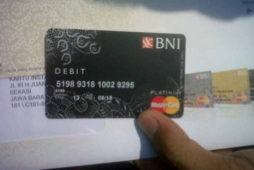 Seorang calon haji dari embarkasi Bekasi menunjukkan kartu debit yang diterimanya di Bekasi, Kamis (12/9). Kerja sama pembuatan rekening ini dilakukan Kementerian Agama dengan BNI, Bank Syariah Mandiri, Bank Mandiri, dan BRI. 