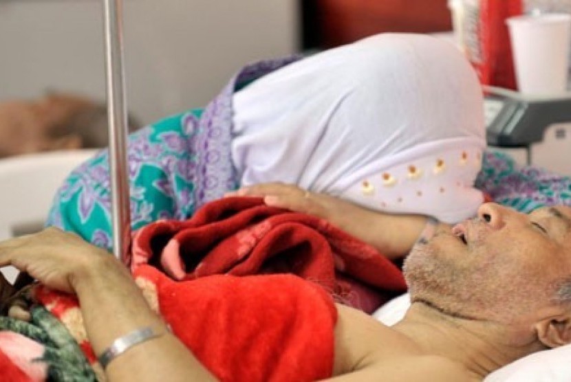 Seorang calon haji terbaring ditemani saudaranya di ruang perawatan Balai Pengobatan Haji Indonesia (BPHI) 