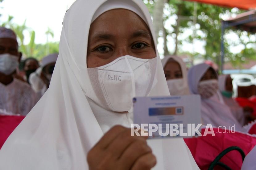 Seorang calon jemaah umrah memperlihatkan kartu vaksin COVID-19 di Dumai, Riau, Sabtu (5/2/2022). Dinkes Riau merilis kasus terkonfirmasi Covid-19 bertambah lima orang.