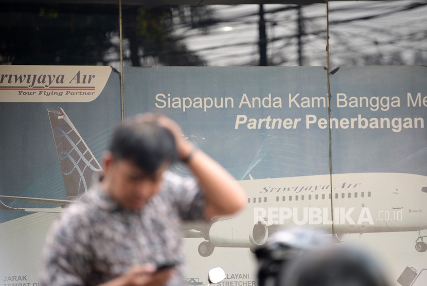 Seorang calon pembeli berada di depan gerai penjualan tiket maskapai Sriwijaya Air di Jakarta, Senin (30/9/2019). 