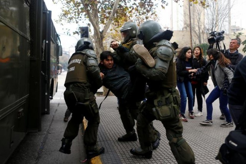 Seorang demonstran ditahan saat unjuk rasa mahasiswa menuntut pemerintah melakukan reformasi pendidikan di Santiago, Cile, 26 Mei 2016.