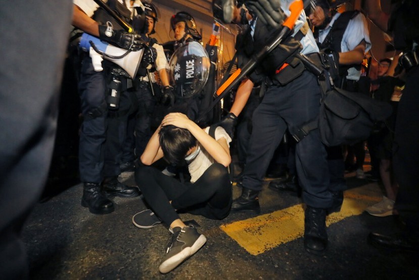 Seorang demonstran melindungi dirinya dari polisi Hong Kong saat protes menentang hukum ekstradisi di Hong Kong, Senin dini hari (10/6).