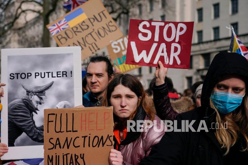  Seorang demonstran memegang plakat saat dia menghadiri demonstrasi di luar Downing Street, di London, Kamis, 24 Februari 2022. Di Taiwan, Presiden Tsai ing-wen mengaku khawatir China akan mengambil momentum serangan Rusia ke Ukraina.