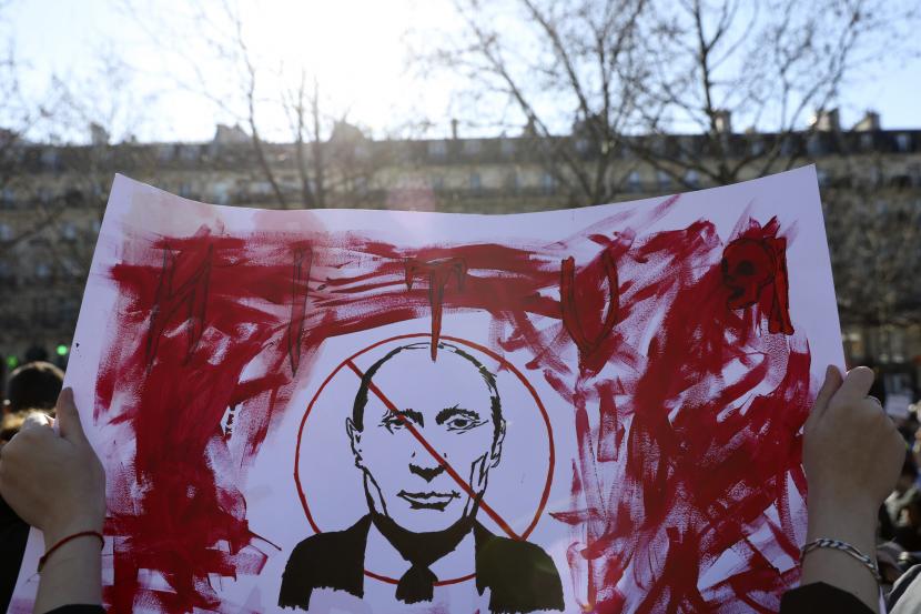 Seorang demonstran memegang poster yang menunjukkan Presiden Rusia Vladimir Putin selama rapat umum memprotes invasi Rusia ke Ukraina, Sabtu, 26 Februari 2022 di Paris. Pemerintah Jepang akan menjatuhkan sanksi kepada Presiden Rusia Vladimir Putin dan pejabat tinggi Rusia lainnya