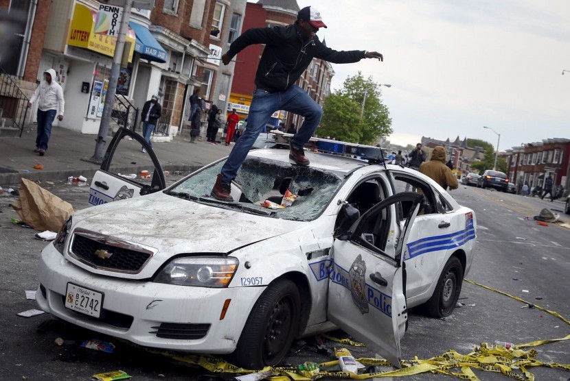 Seorang demonstran merusak mobil polisi di Baltimore, Maryland, AS, Senin (27/4)