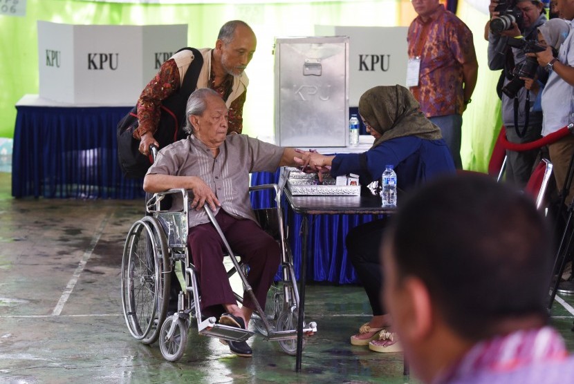 Seorang disabilitas mengikuti proses pencoblosan Pilkada DKI Jakarta di TPS 6, Rawa Barat, Jakarta, Rabu (15/2). 