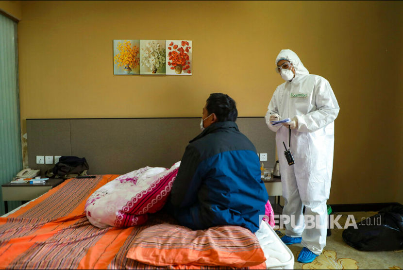 Hubei Laporkan 81 Korban Tewas Akibat Corona. Seorang dokter dengan pakaian pelindung memeriksa pasien di hotel yang digunakan sebagai tempat isolasi warga di Wuhan, Hubei, China. 