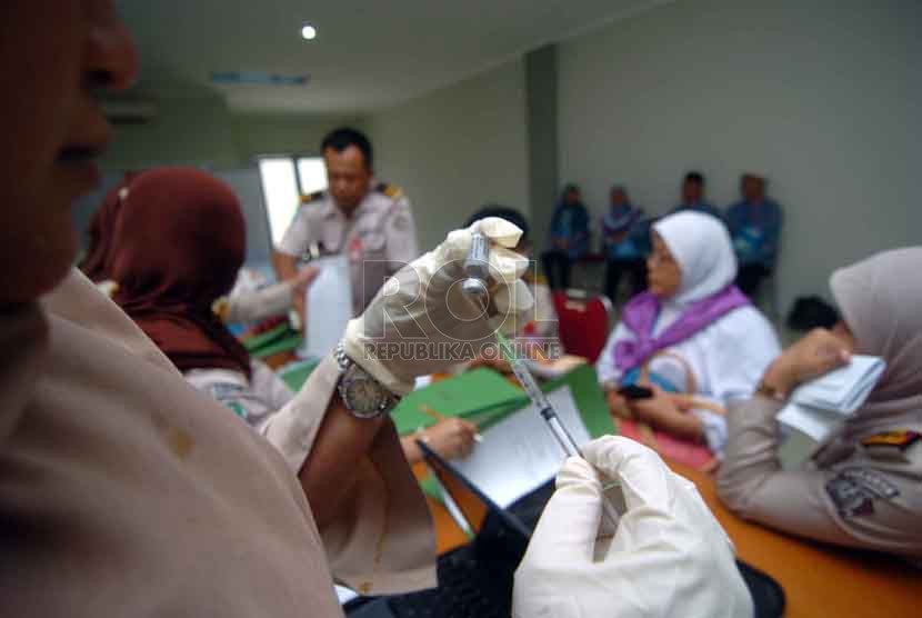 Seorang dokter memasukan vaksin meningitis di puskesmas Pondok Asrama haji, Pondok Gede, Jakarta Timur, Ahad (31/8).(Republika/Raisan Al Farisi)