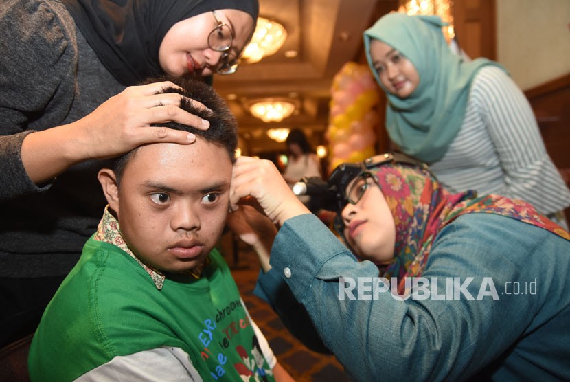 Seorang dokter memeriksa kebersihan telinga penyandang Down Syndrome pada puncak peringatan Hari Down Syndrome Dunia 2018 di Surabaya, Jawa Timur, Rabu (21/3). 