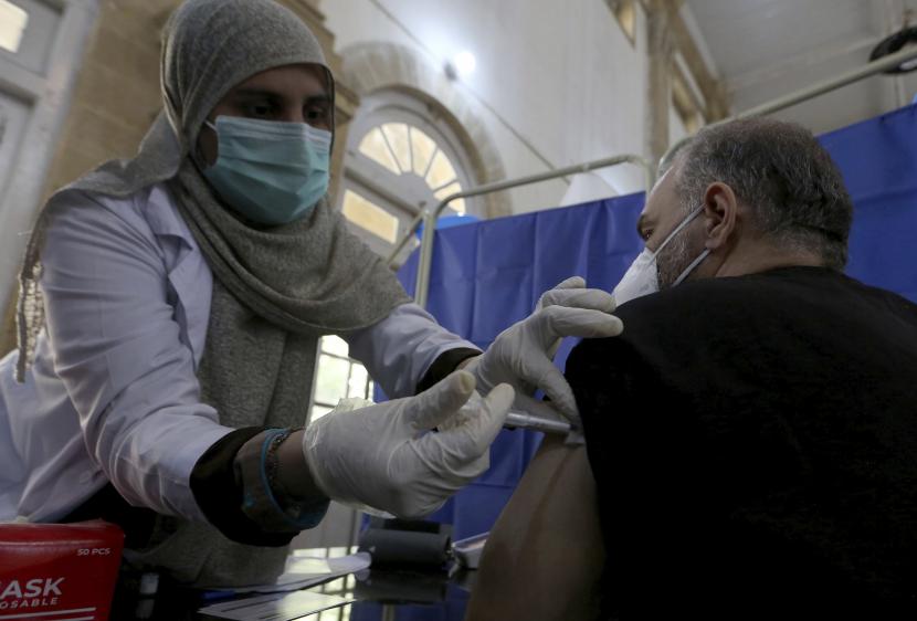 Seorang dokter menerima vaksin virus corona Sinopharm dari seorang perawat di pusat vaksinasi, di Karachi, Pakistan, Rabu, 3 Februari 2021.