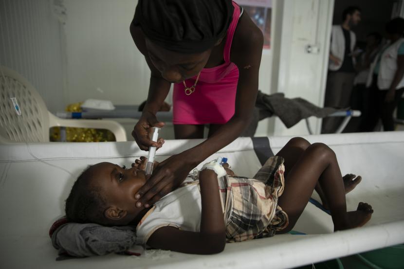 Seorang gadis dengan gejala kolera dibantu oleh ibunya di sebuah klinik yang dikelola oleh Doctors Without Borders, di lingkungan Delmas Port-au-Prince, Haiti, Kamis, 10 November 2022. Di Haiti, banyak pasien sekarat karena mengatakan mereka tidak dapat mencapai rumah sakit tepat waktu, kata pejabat kesehatan.