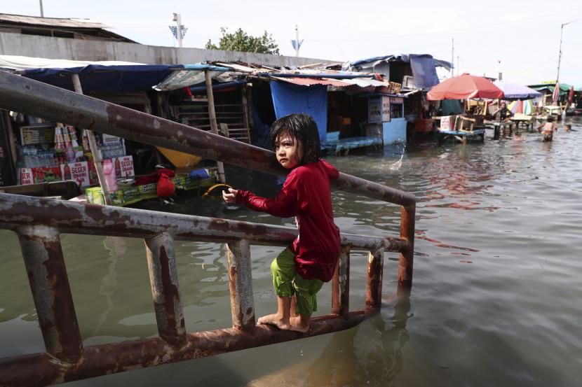 Seorang gadis muda bermain saat banjir rob di Pelabuhan Muara Angke di Jakarta, belum lama ini.