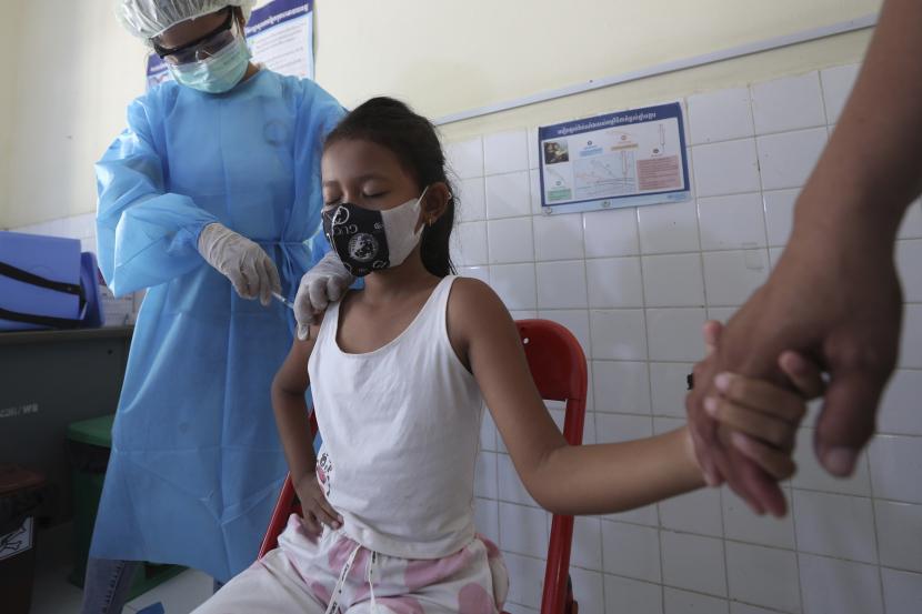 Seorang gadis muda memegang tangan ibunya saat dia menerima suntikan vaksin COVID-19 Sinovac di pusat kesehatan Samrong Krom di luar Phnom Penh, Kamboja, Jumat,17 September 2021.