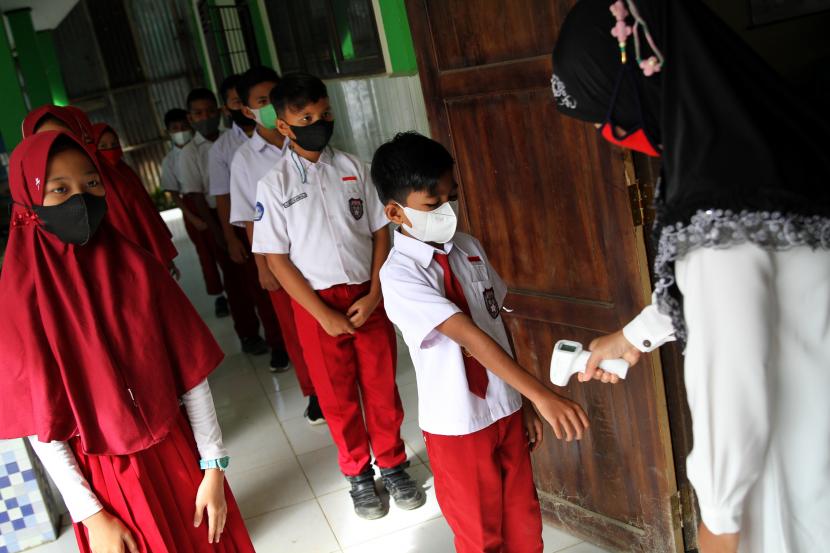 Seorang guru melakukan pengecekan suhu tubuh siswa sebelum masuk ke dalam kelas di SD Negeri 10 Kendari, Kendari, Sulawesi Tenggara (ilustrasi)