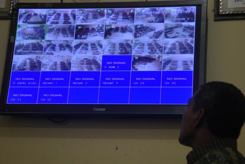 Seorang guru melihat monitor Closed Circuit Television (CCTV) yang digunakan untuk mengawasi ujian nasional di SMK Negeri 1 Banyudono, Boyolali, Jawa Tengah, Jumat (10/4).