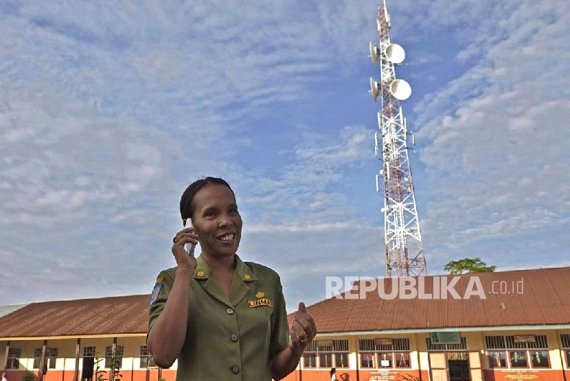 Seorang guru menggunakan layanan jaringan Telkomsel, di Tobelo, Halmahera Utara, belum lama ini.