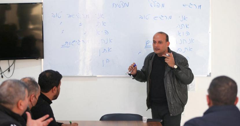 Seorang guru Palestina mengajar bahasa Ibrani ke sekelompok siswa di Nafha Language Center, Khan Younis, selatan Jalur Gaza, 16 Februari 2022.