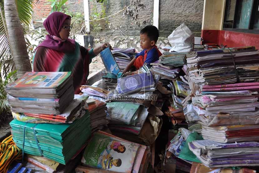 Seorang Guru SDN 07 Petamburan menyortir buku-buku yang basah akibat banjir yang merendam kawasan Petamburan Jakarta Barat,Senin (21/1).(Republika/Rakhmawaty La'lang)