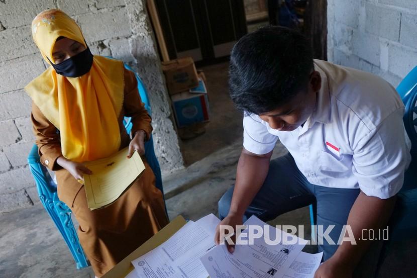 Seorang guru SMA Negeri 1 Kabila mengawasi siswa yang melakukan ujian semester secara luar jaringan (luring) di rumah di Poowo Barat, Kabupaten Bone Bolango, Gorontalo, Selasa (9/6/2020). Hal yang sama dilakukan sejumlah guru di wilayah selatan Cianjur, Jawa Barat, Kesulitan internet membuat guru mendatangi rumah muridnya.