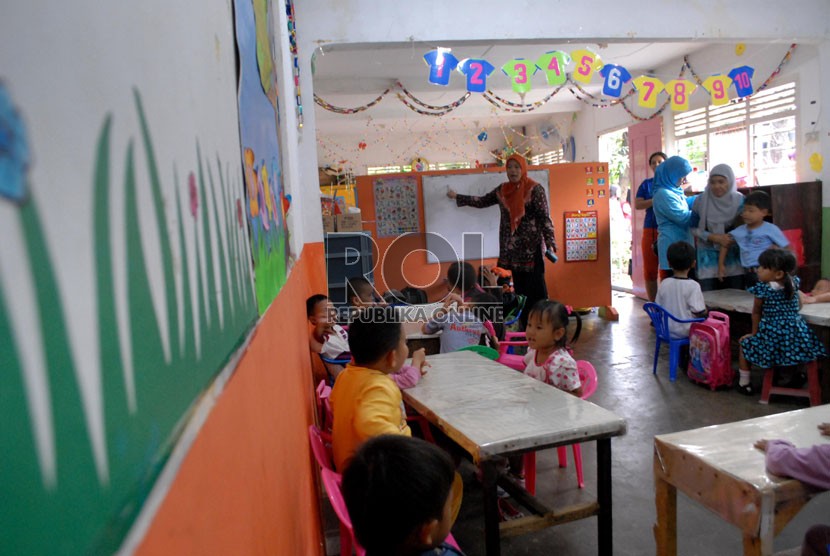 Seorang guru tengah membimbing muridnya di BKB Pendidikan Anak Usia Dini (PAUD) Mawar, Manggarai, Jakarta Selatan, Jakarta Pusat, Kamis (30/8).  ( Republika/Rakhmawaty La'lang)