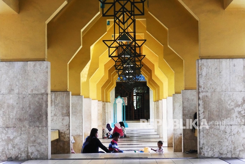 Seorang ibu bermain dengan anak-anaknya di pelataran masjid Islamic Cener Jakarta.