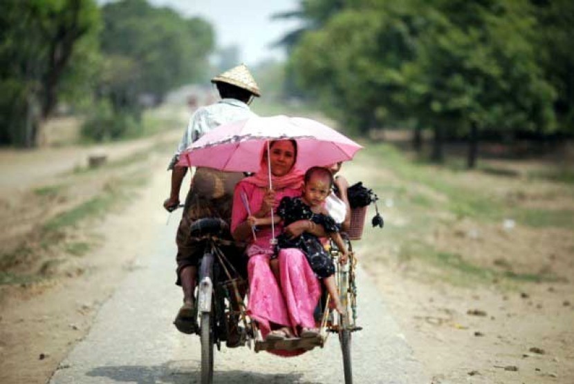  Seorang ibu dari etnis Rohingya beserta anaknya naik becak di sebelah Utara jalan kota Sittwe, Myanmar. 