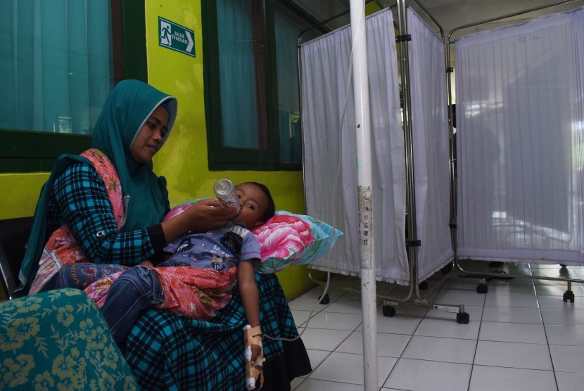 Seorang ibu memangku anaknya yang diduga terserang Demam Berdarah (DB) di lorong Rumah Sakit Umum Daerah (RSUD) Dolopo, Kabupaten Madiun, Jawa Timur, Senin (4/2/2019). 