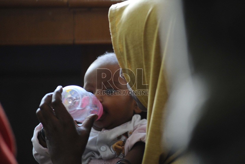  Seorang ibu memberi air minum anaknya yang berusia 4 bulan saat mengungsi di Gedung LBH Jakarta, Selasa (9/7). (Republika/ Tahta Aidilla)