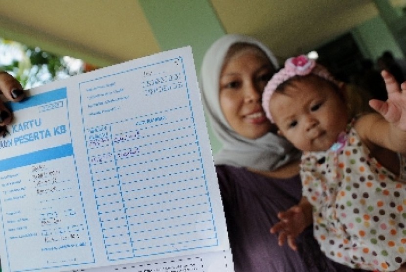 Seorang ibu memperlihatkan kartu peserta Keluarga Berencana (KB).