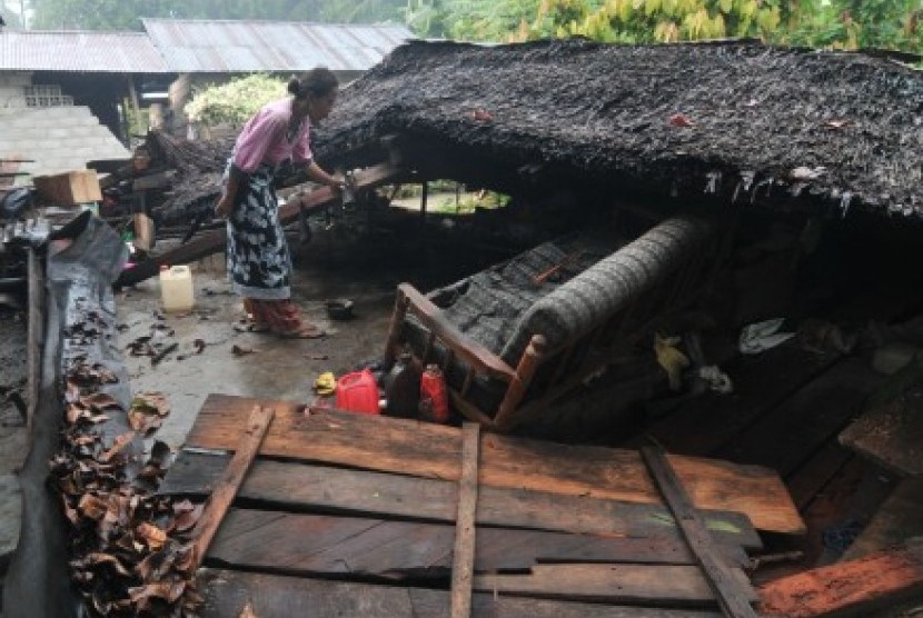   Seorang ibu mencari barang-barang yang masih bisa diselamatkan dari reruntuhan rumah akibat gempa bumi di Desa Tuva, Kecamatan Gumbasa, Kab. Sigi, Sulawesi Tengah, Ahad (19/8). 