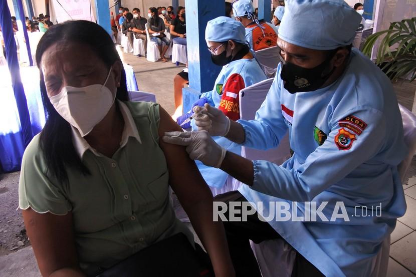 Seorang ibu menerima suntikan vaksin Covid-19 dosis pertama ketika dilaksanakan vaksinasi Covid-19 bagi perempuan dan remaja di kantor Ditlantas Polda NTT, Kota Kupang, NTT.
