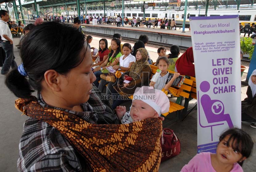  Seorang ibu menggendong anaknya di dekat papan kampanye gerakan moral bangku untuk ibu hamil . (Ilustrasi)