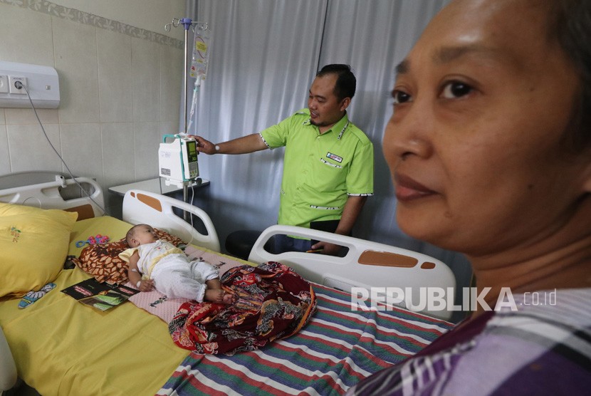 Seorang ibu menjaga anaknya yang terserang Demam Berdarah Dengue (DBD) di Rumah Sakit Umum Daerah Simpang Lima Gumul, Kediri, Jawa Timur, Senin (28/1/2019).