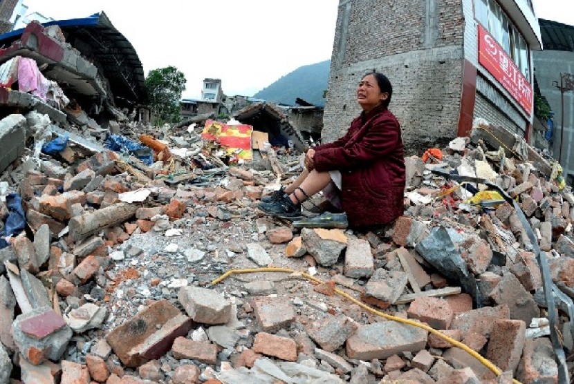 Seorang ibu merapat dan menangis setelah gempa besar melanda Cina Barat