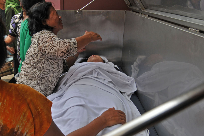    Seorang ibu meratapi kepergian putrinya yang menjadi korban keracunan gas genset di Klinik dan apotik Sapta Mitra, Pondok Timur Bekasi, Jawa Barat, Selasa (11/2).    (Antara/Paramayuda)
