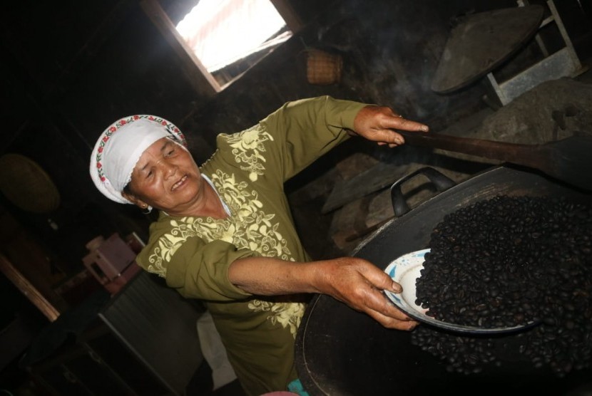 Seorang ibu tengah menyangrai kopi robusta asal Semende