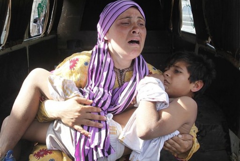 Seorang ibu warga Suriah menggendong anaknya yang jadi korban penembakan di dekat perbatasan Suriah-Lebanon.