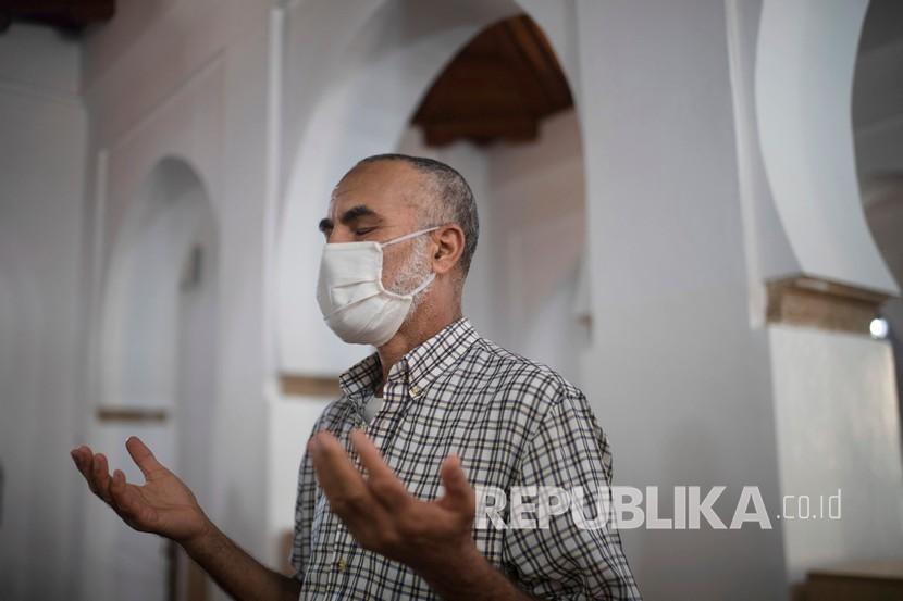  Seorang jamaah berdoa sambil mengenakan masker di dalam masjid yang dibuka kembali di Rabat, Maroko, Rabu (15/7/2020).