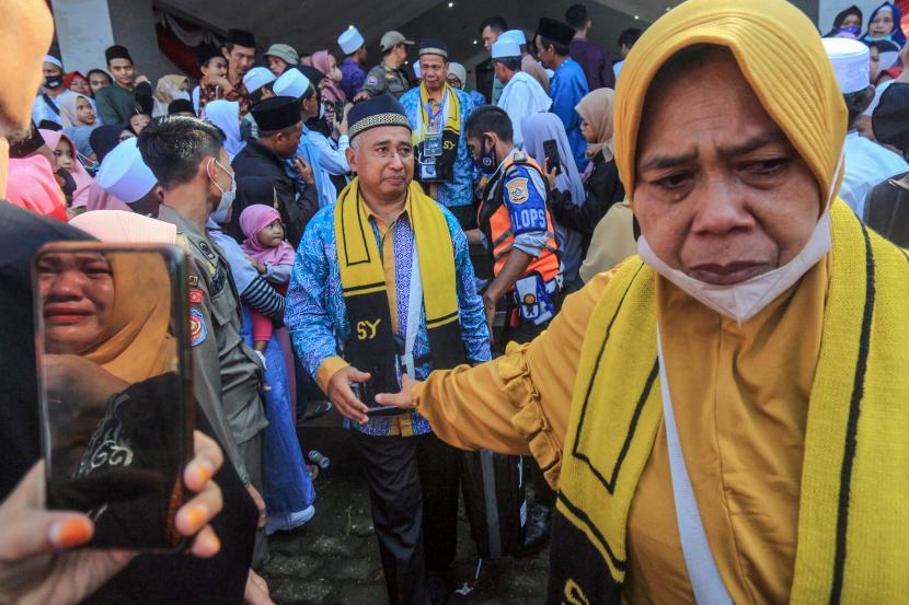 Seorang jamaah calon haji menangis saat berpamitan dengan keluarganya saat pelepasan keberangkatan di halaman Pemkab Bogor, Cibinong, Kabupaten Bogor, Jawa Barat, Sabtu (4/6/2022). 