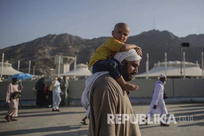 Seorang jamaah haji cilik yang plontos digendong ayahnya menuju Jamarat untuk melempar Jumrah Aqabah.
