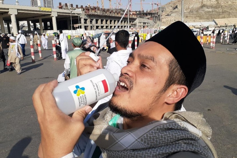 Seorang jamaah haji Indonesia asal Surabaya sedang meminum air dari botol di Terminal Syib Amir, Makkah.