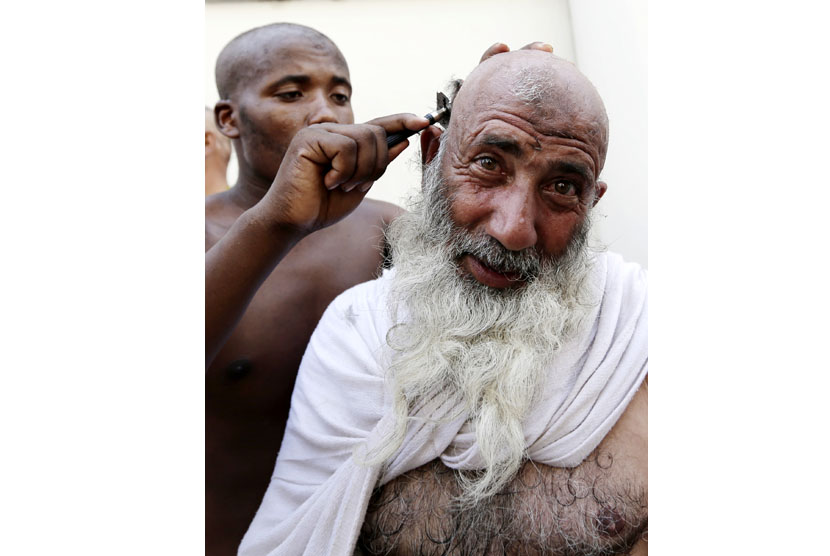   Seorang jamaah haji mencukur rambutnya usai melontar jumrah Aqabah di Mina, dekat kota suci Makkah, Jumat (26/10).    (Hassan Ammar/AP)